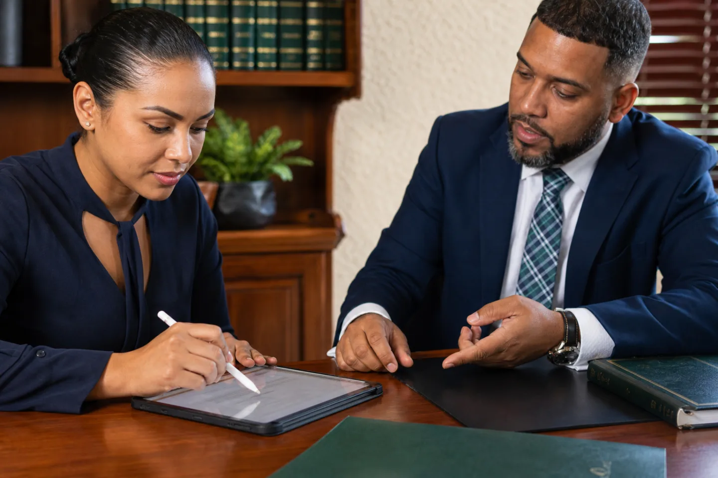 A client completing a digital acknowledgement while an attorney explains the next step.